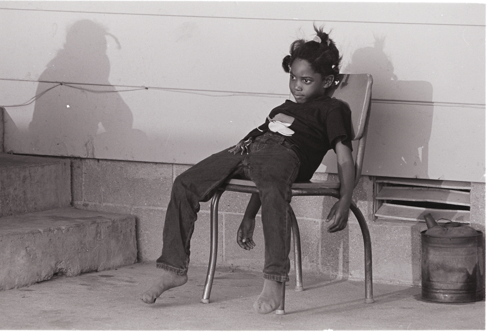 A young child sits in a chair.