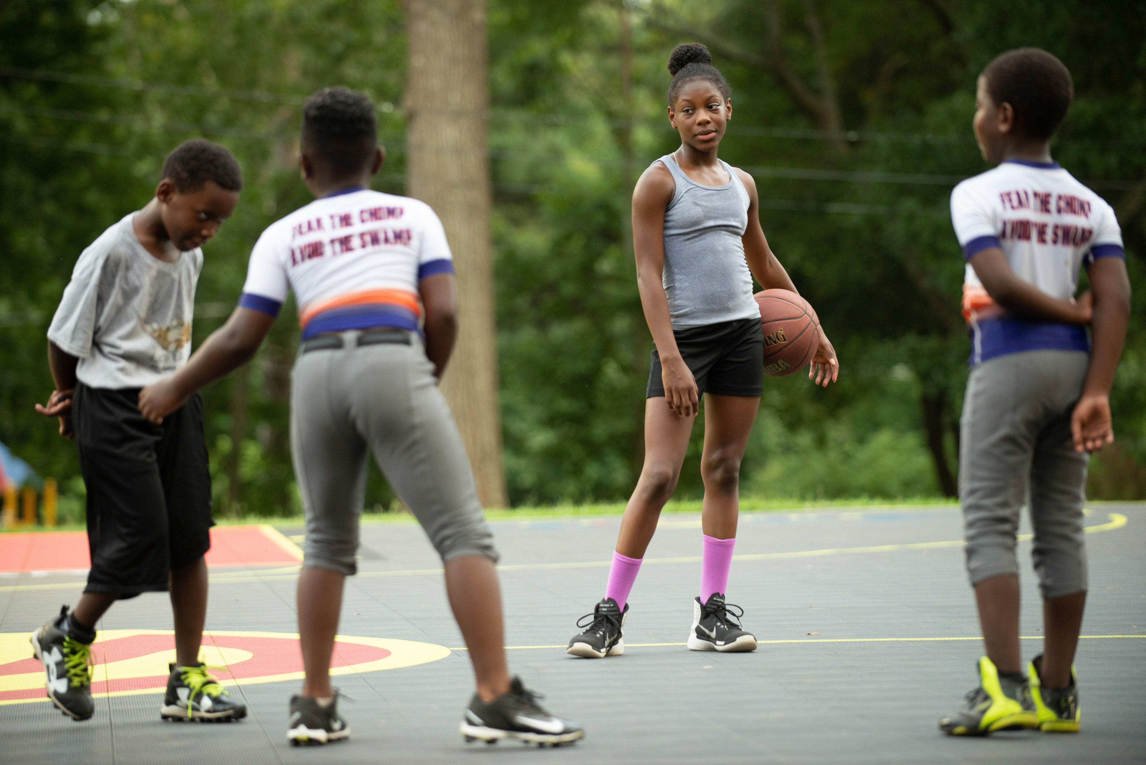 A group of young people stand on a basketball court.