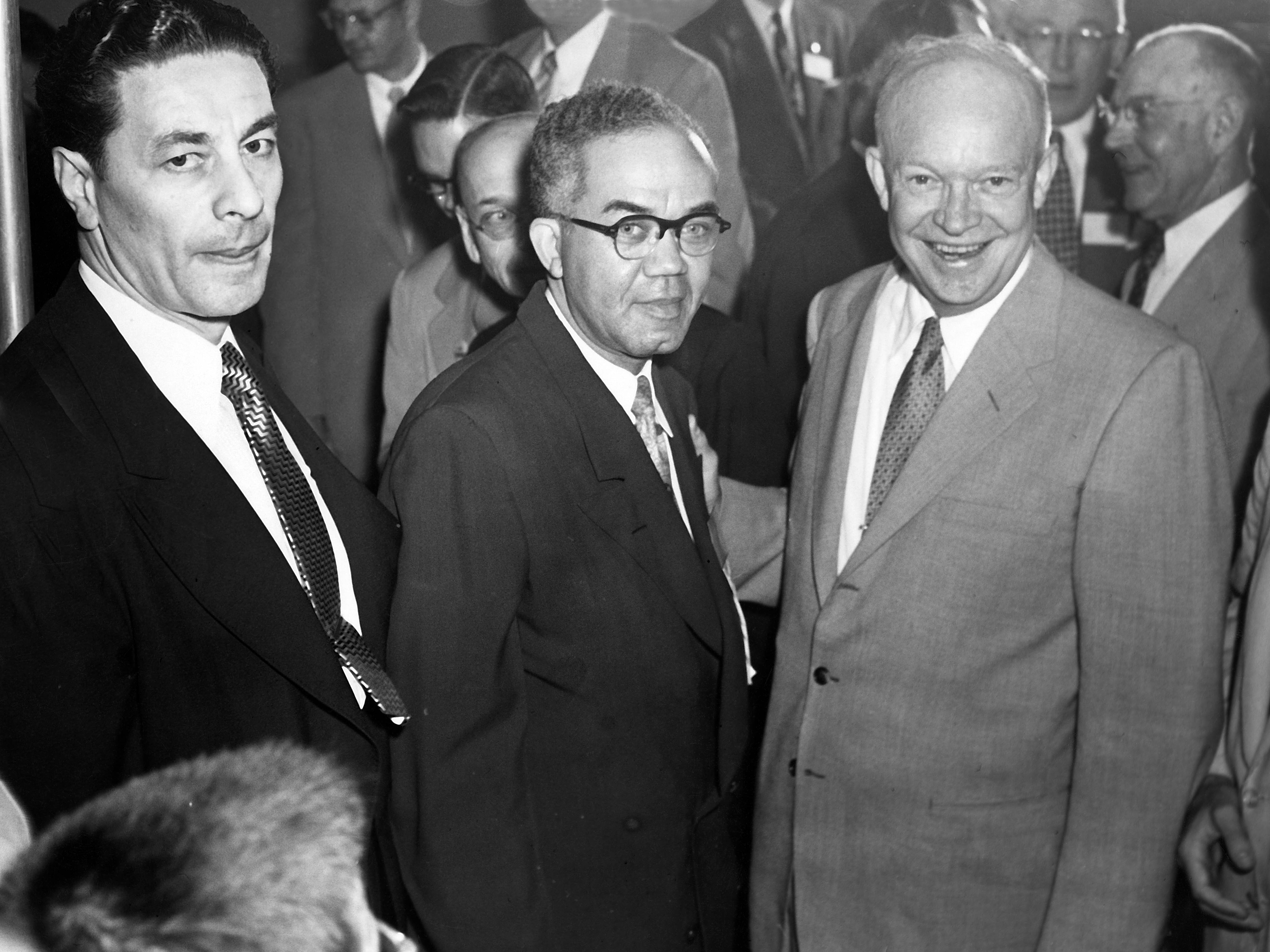 Men stand next to President Dwight D. Eisenhower.