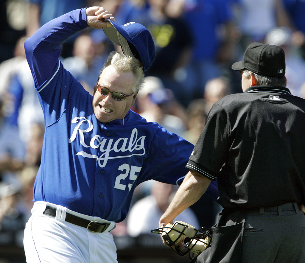 A manager of the Kansas City Royals baseball team throws his cap to the ground during an exchange with the umpire.