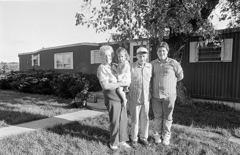 A family poses for a photo outside their home.