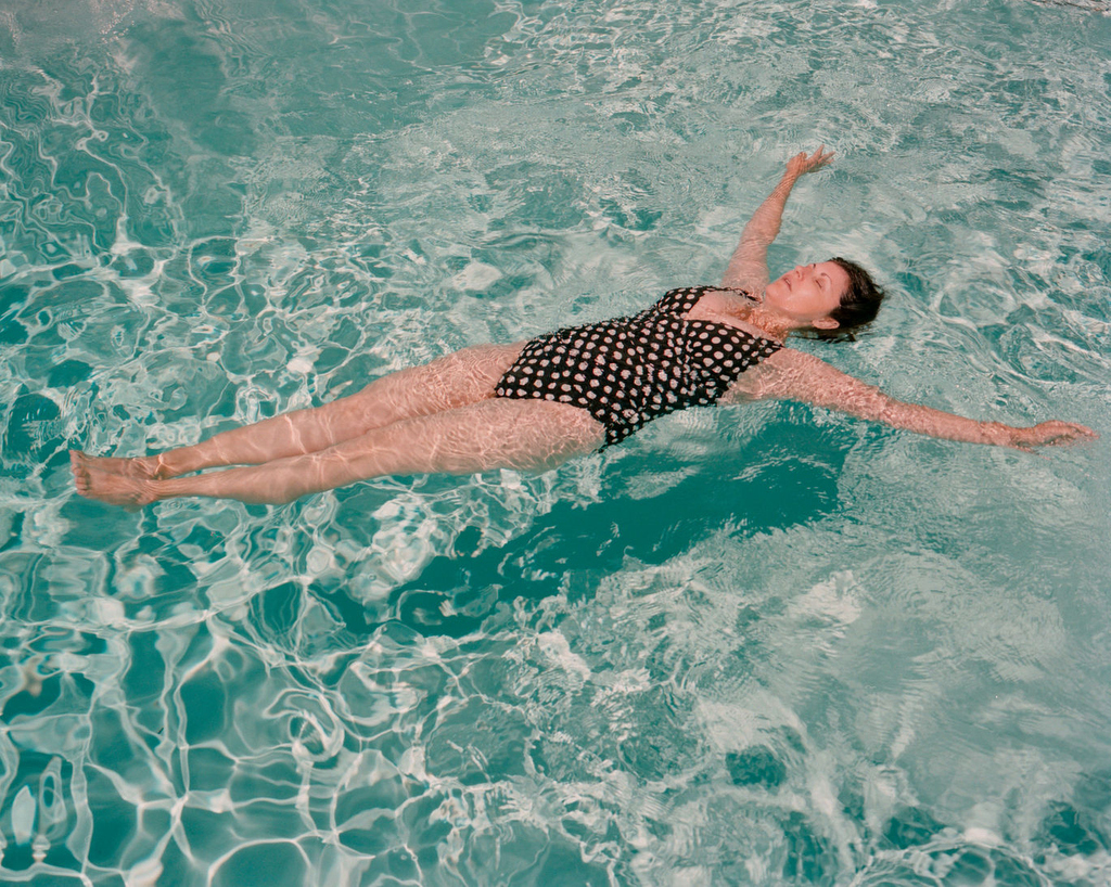 A woman floats on her back in a pool.