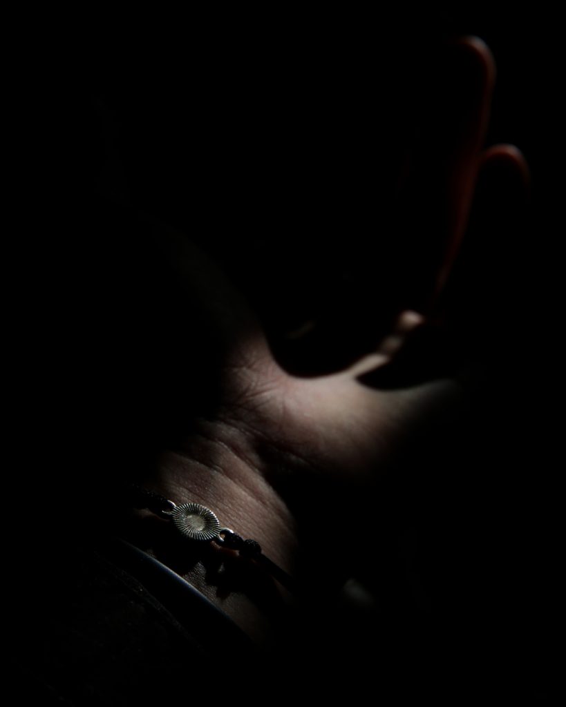 A palm of a hand stands against a dark background.