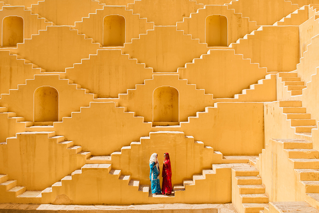 photograph of two women on stairs by a well