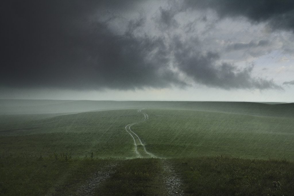 A rainstorm moves across a green Kansas prairie.