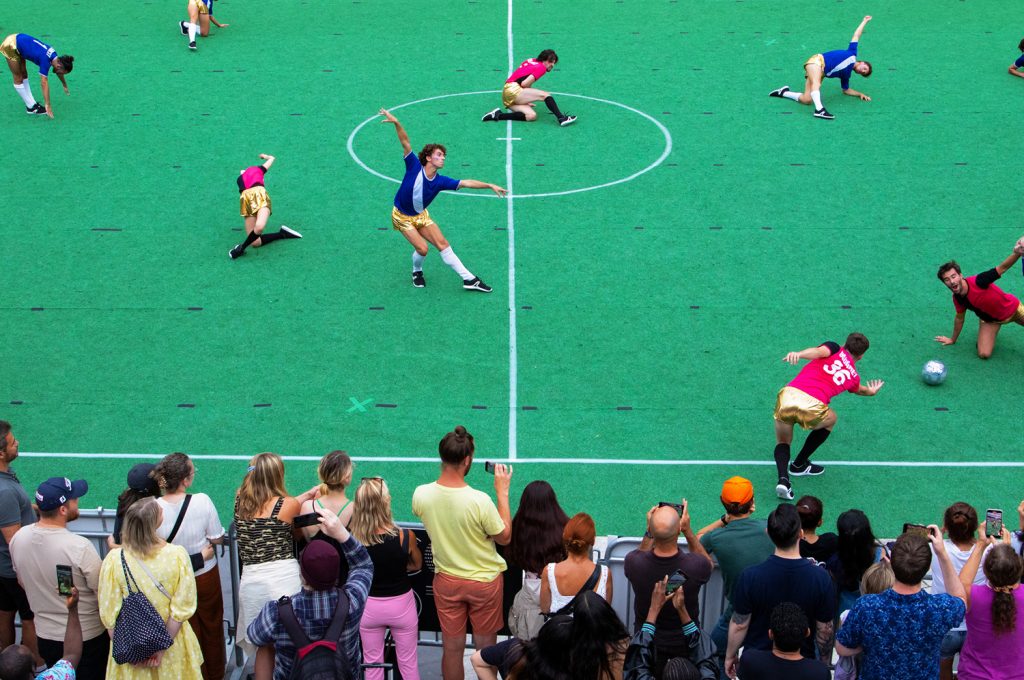 People dance while playing soccer.