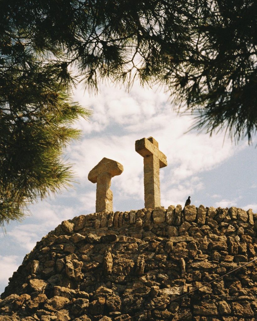 Two stone sculptures stand atop a hill.
