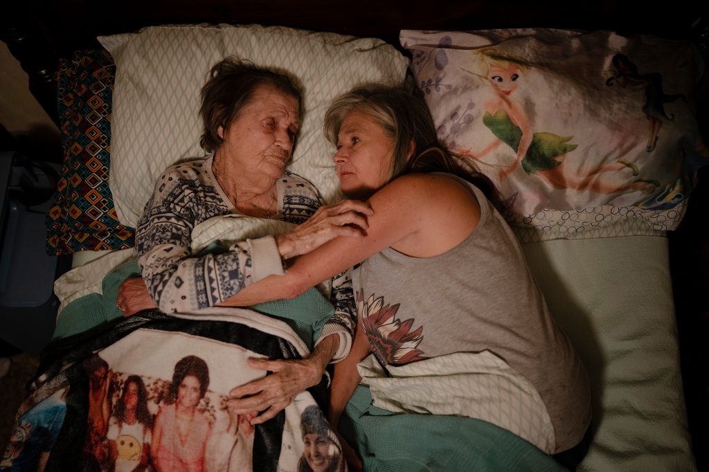 Photograph of two women laying in bed