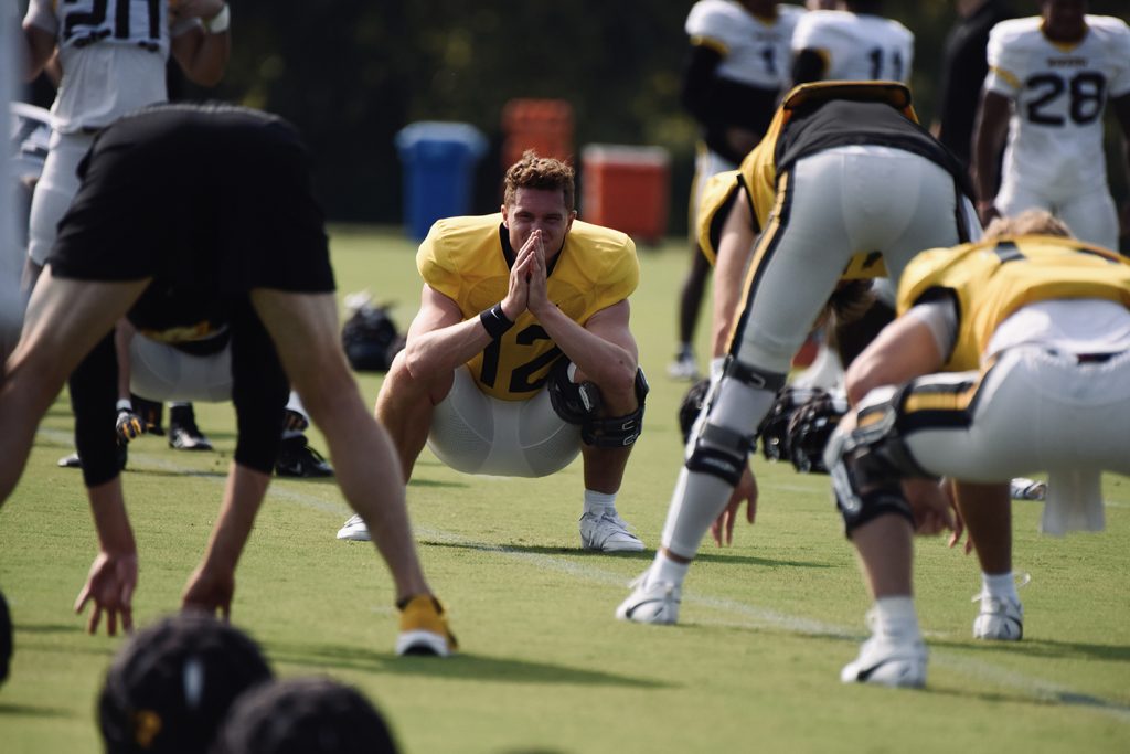 Photograph of University of Missouri football players stretching before practice