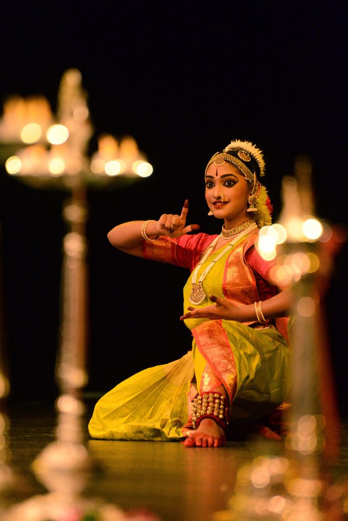 Photograph of a woman in traditional Indian clothing performing a dance.