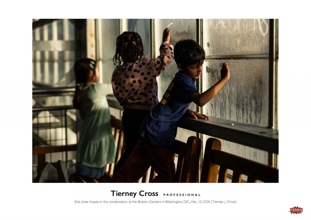 Photograph of children drawing with their fingers on fogged up windows.